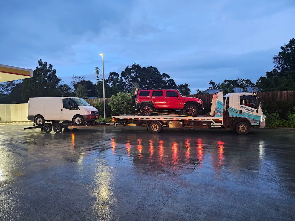 A Tow Truck is Carrying a Red Jeep and a White Van — Optimum Towing in Sanctuary Point, NSW