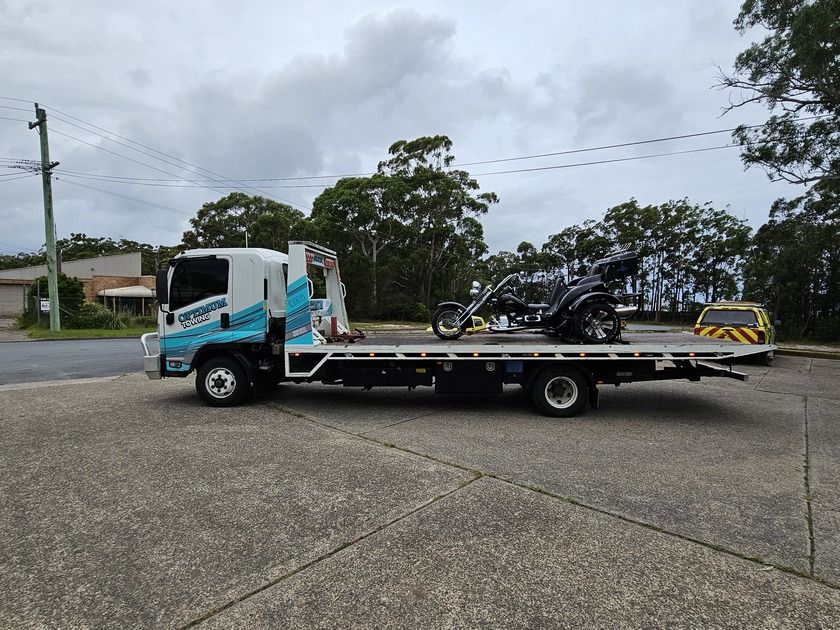 A Tow Truck is Carrying a Motorcycle on the Back of It — Optimum Towing in Bomaderry, NSW