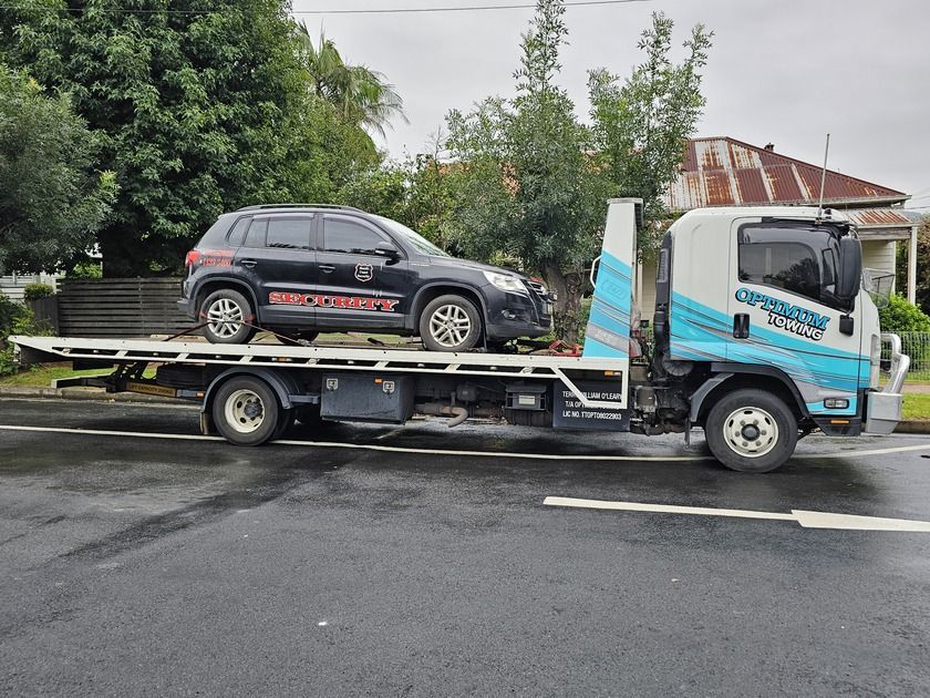 A Tow Truck is Carrying a Car on the Back of It — Optimum Towing in Bomaderry, NSW