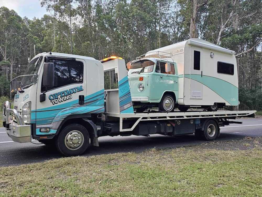 A Tow Truck Carries a Vintage Teal VW Camper Van on a Flatbed — Optimum Towing in Bomaderry, NSW