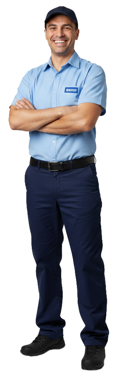 Smiling person in a light blue shirt and dark pants, standing with arms crossed on a white background