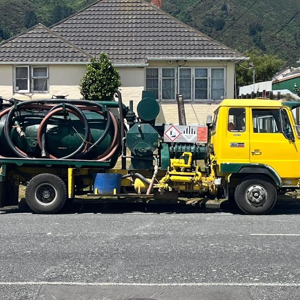 A yellow truck is parked in front of a house.
