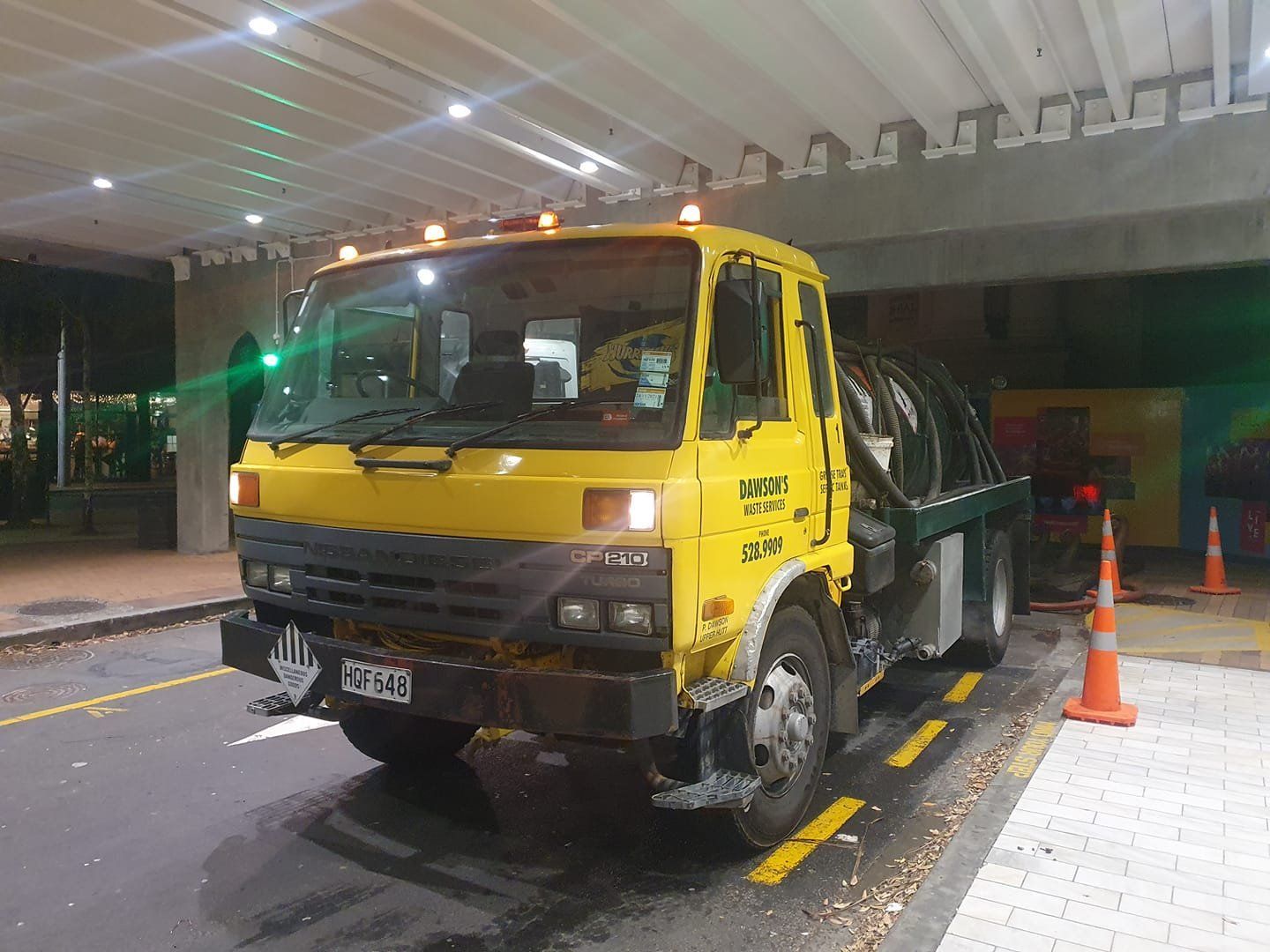 A yellow tow truck is parked on the side of the road.
