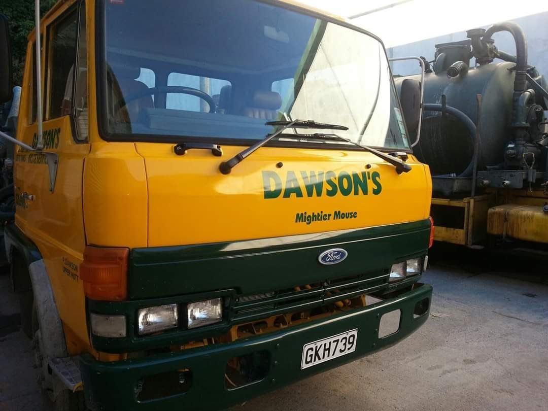 A yellow truck with the word dawson's on the front.
