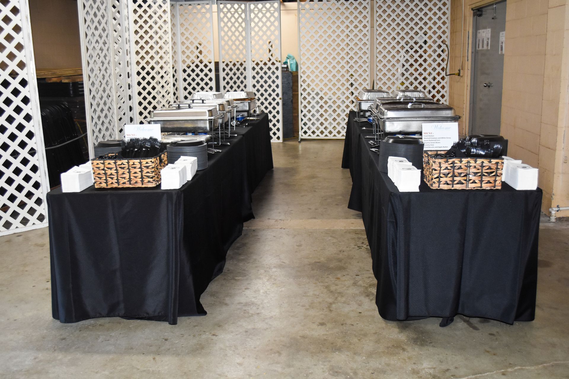Buffet tables with covered dishes and trays in an indoor hall
