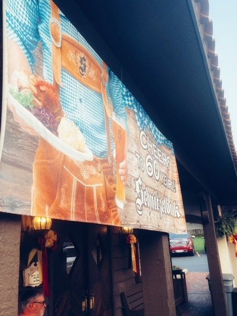 Billboard ad above a storefront beside a street, with orange and blue graphics and text.
