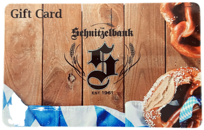 Gift card with Schnitzelbank logo on wood background, framed by blue ribbon and pretzel