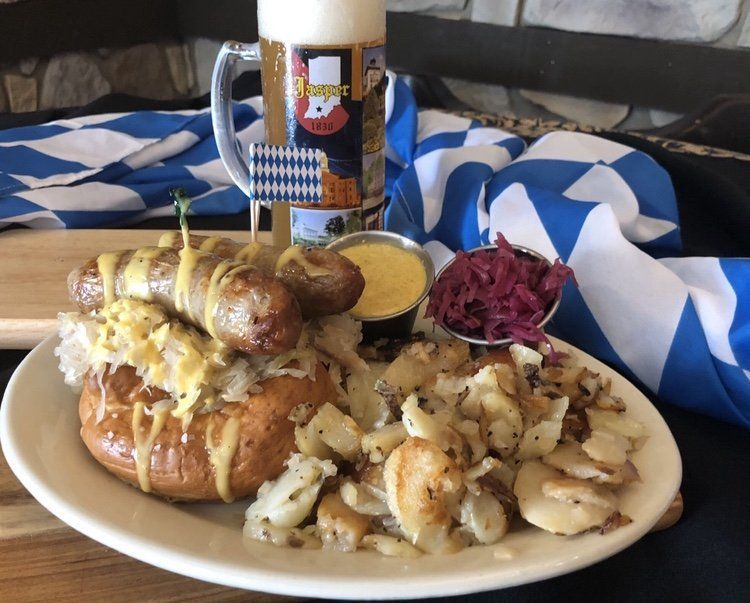 Breakfast plate with eggs, sausages, potatoes, bread, slaw, and a coffee mug on a table