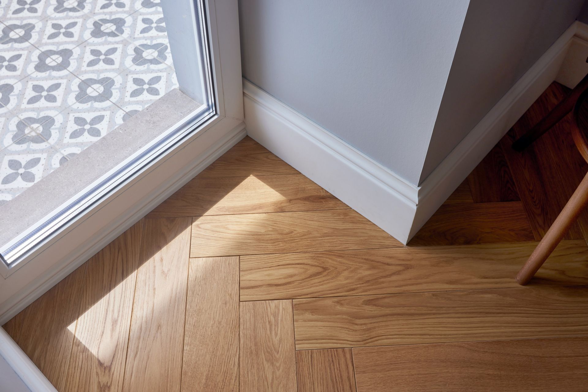 A wooden floor in a room next to a window