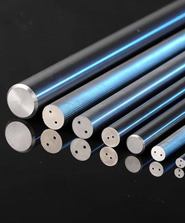 A bunch of metal rods are lined up on a black surface.