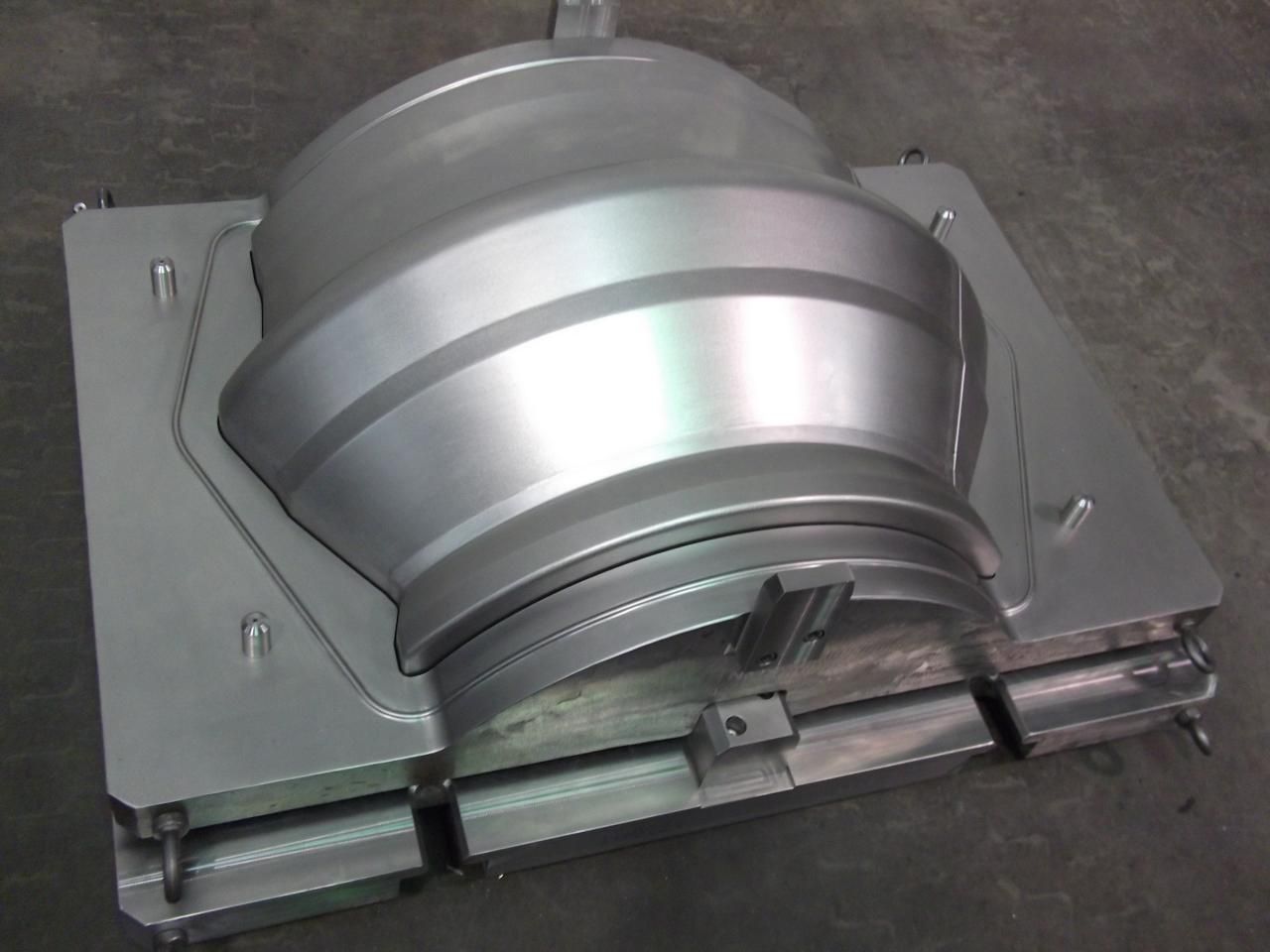A metal mould is sitting on a concrete surface