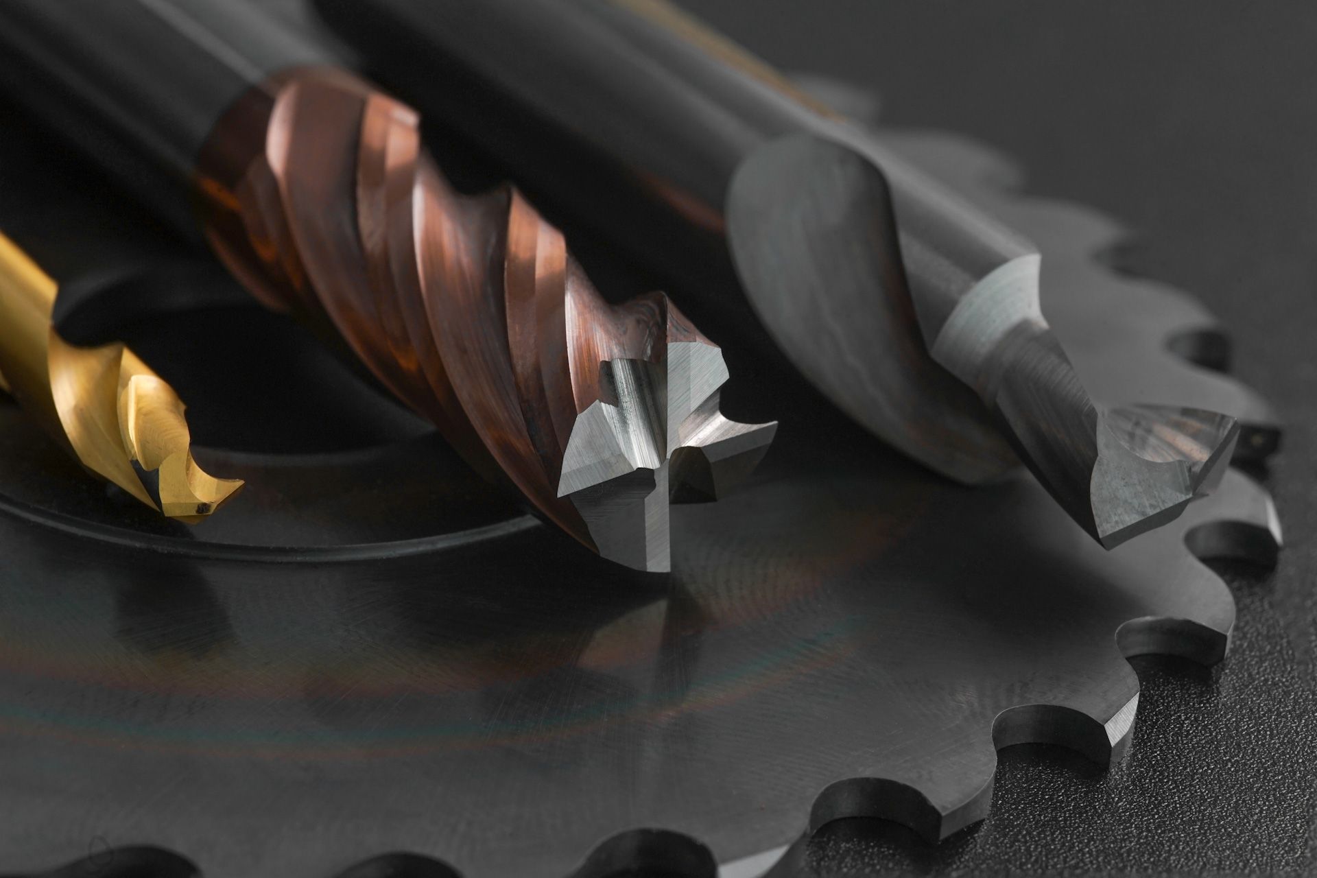 A group of drill bits and a circular saw blade on a table.