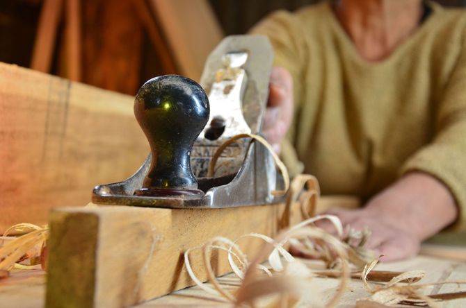 Close-up of a hand planer smoothing a wood block