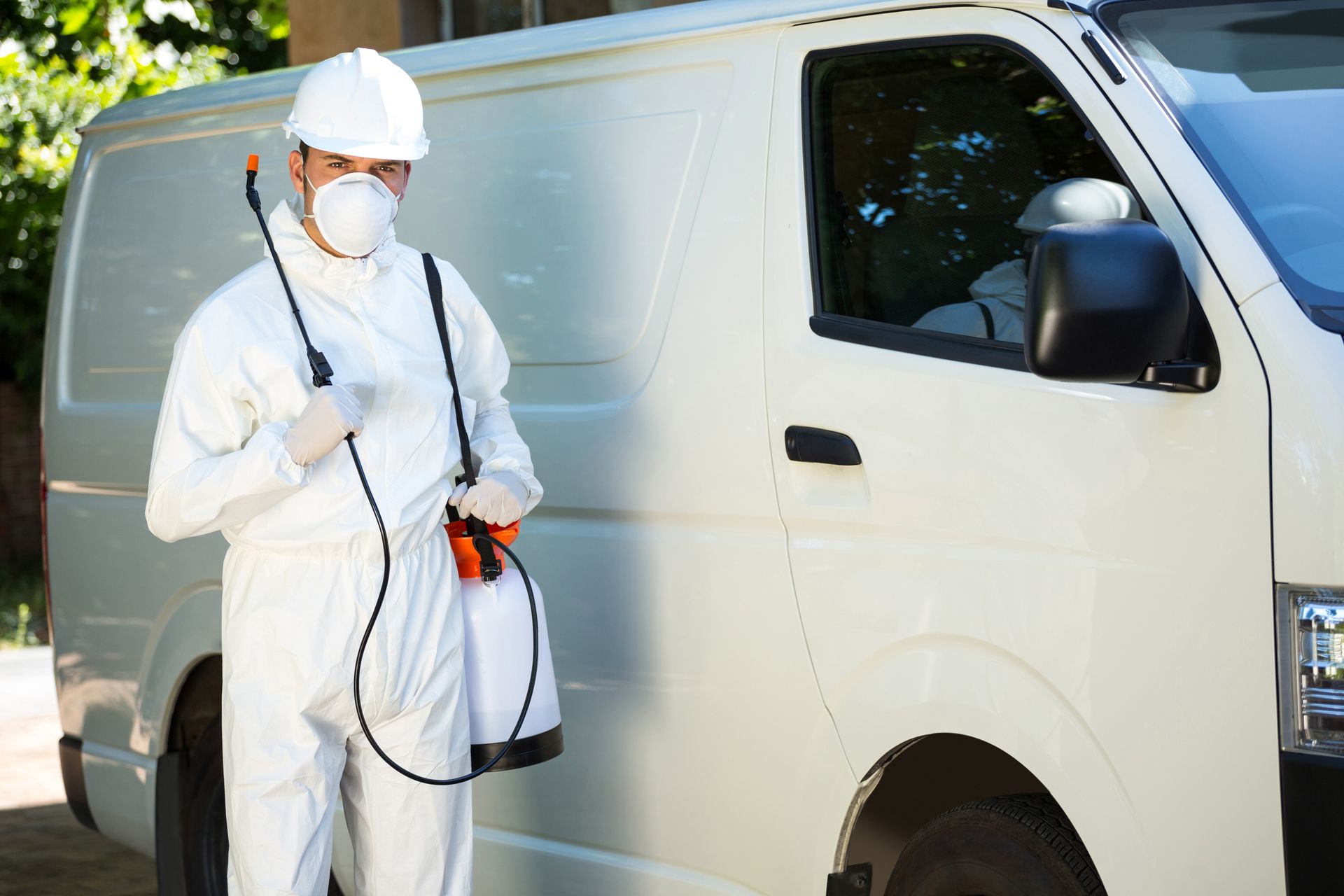 Pest control man standing next to a van.