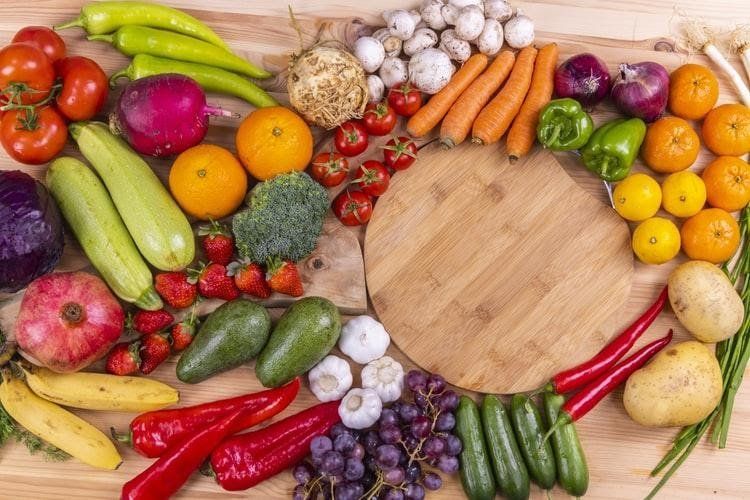 A wooden table topped with a variety of fruits and vegetables.