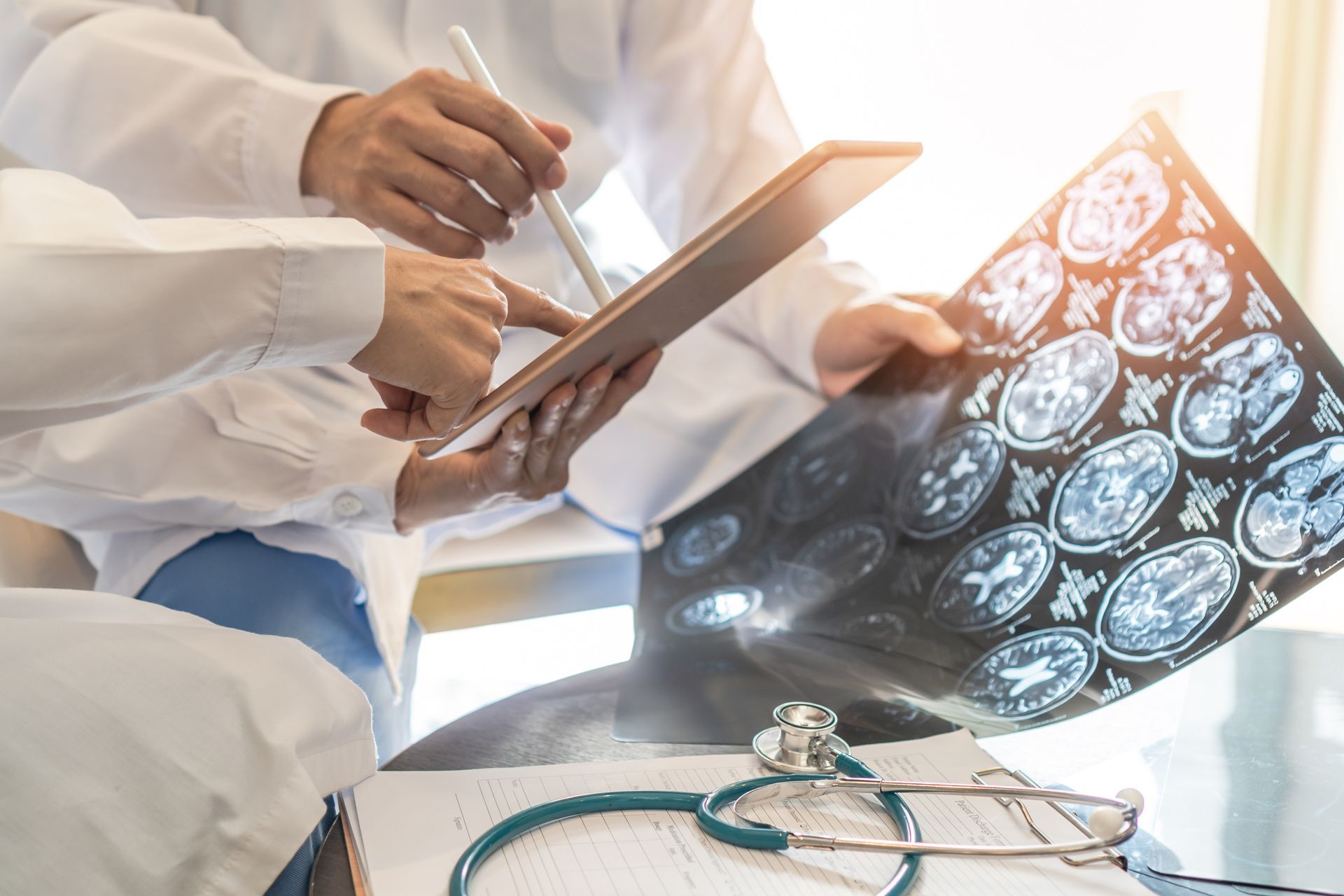 A group of doctors are looking at an x-ray of a patient 's brain.