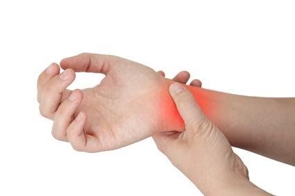 A person is holding their wrist in pain.