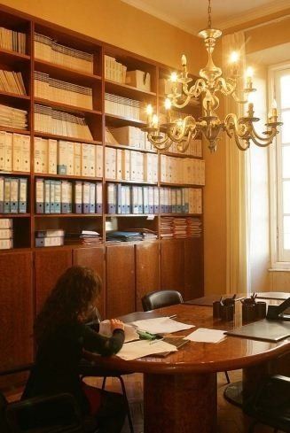 una donna è seduta a un tavolo in una stanza con un lampadario .