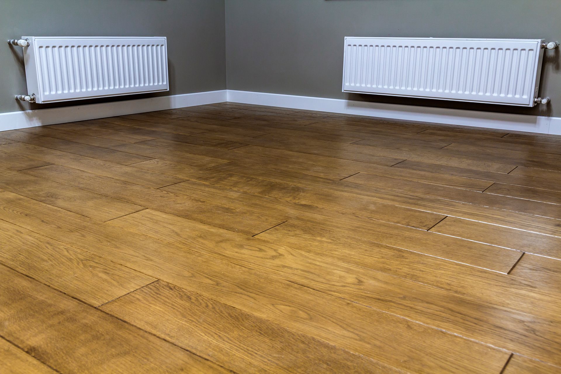 White heating radiators in clean apartment, dust-free floor sanding by All Brite Floors Houston