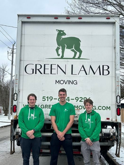 Three Green Lamb Moving staff standing in front of a moving truck with company logo.
