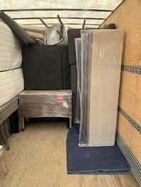 A moving truck filled with furniture and mattresses.