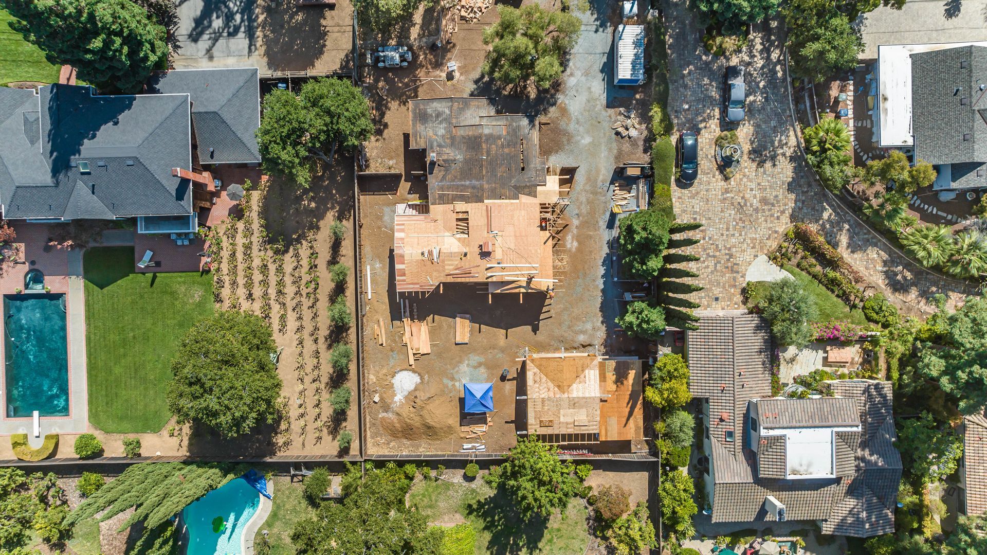 Aerial view of a residential neighborhood with houses, trees, and swimming pools.