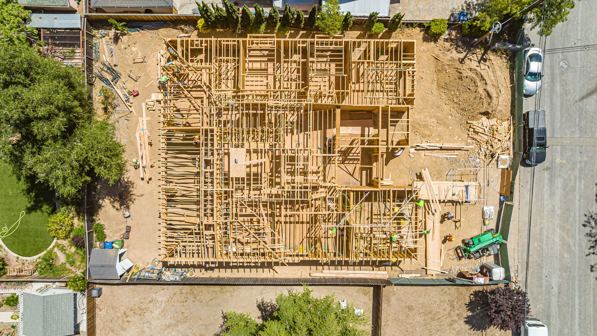 Aerial view of a house foundation under construction with wood framing and surrounding dirt lot