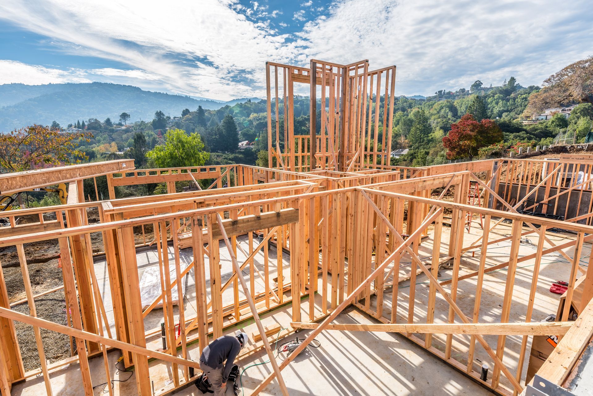 Wood-framed house under construction with mountain views in the background