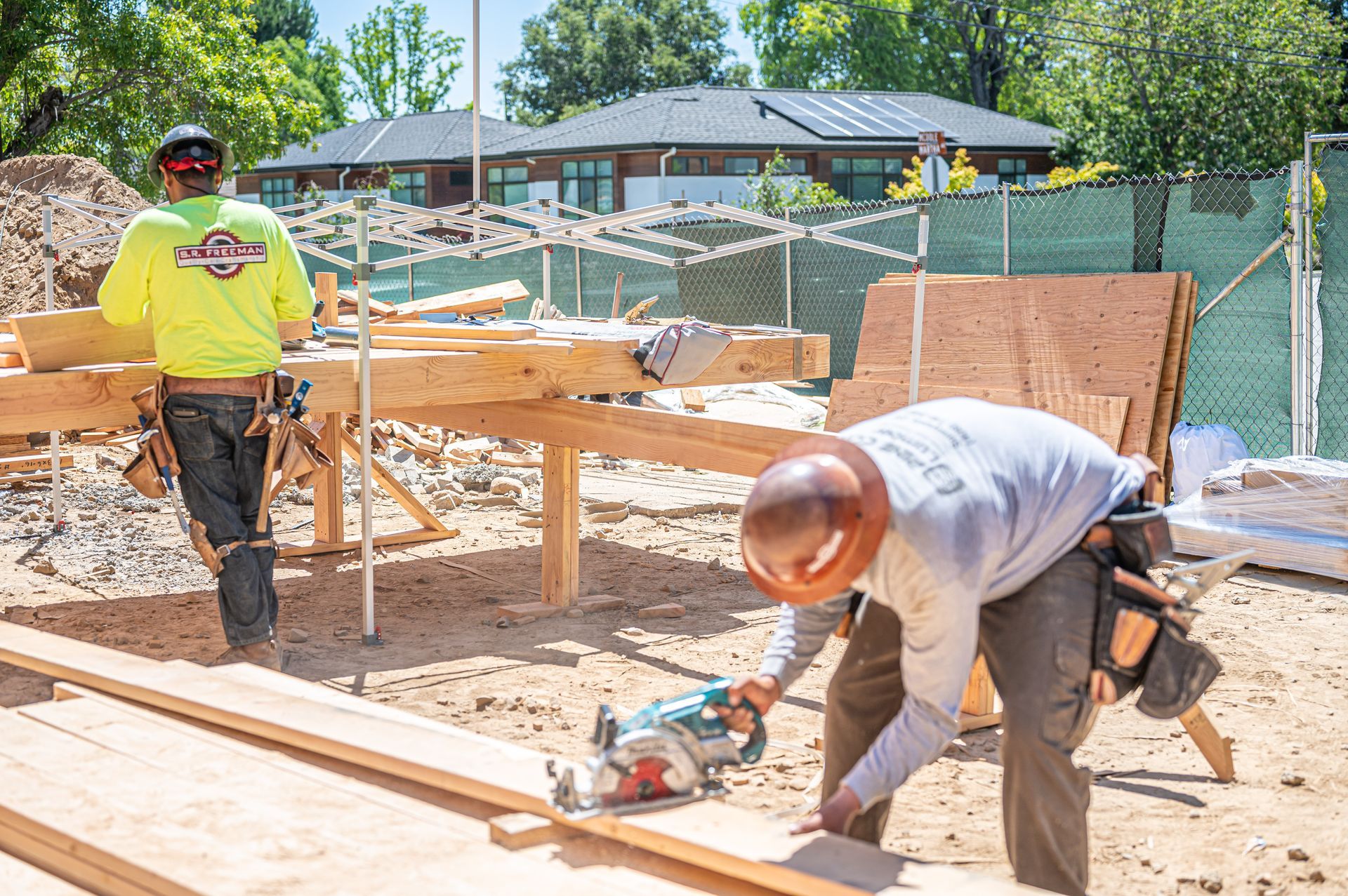 Construction workers building a wooden frame on a sunny outdoor job site