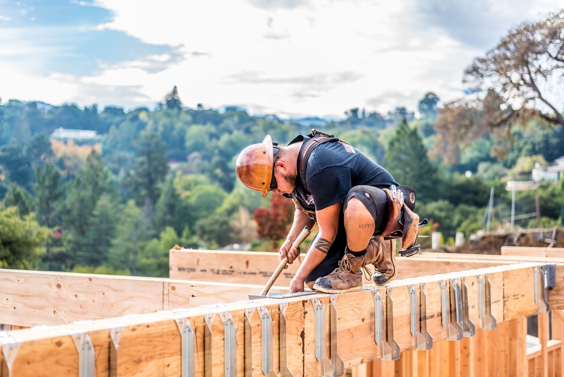 Construction worker laying bricks on a wall at an outdoor building site