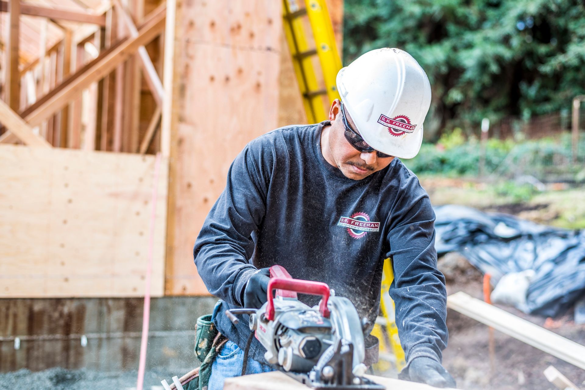 Construction worker using a circular saw at an outdoor building site