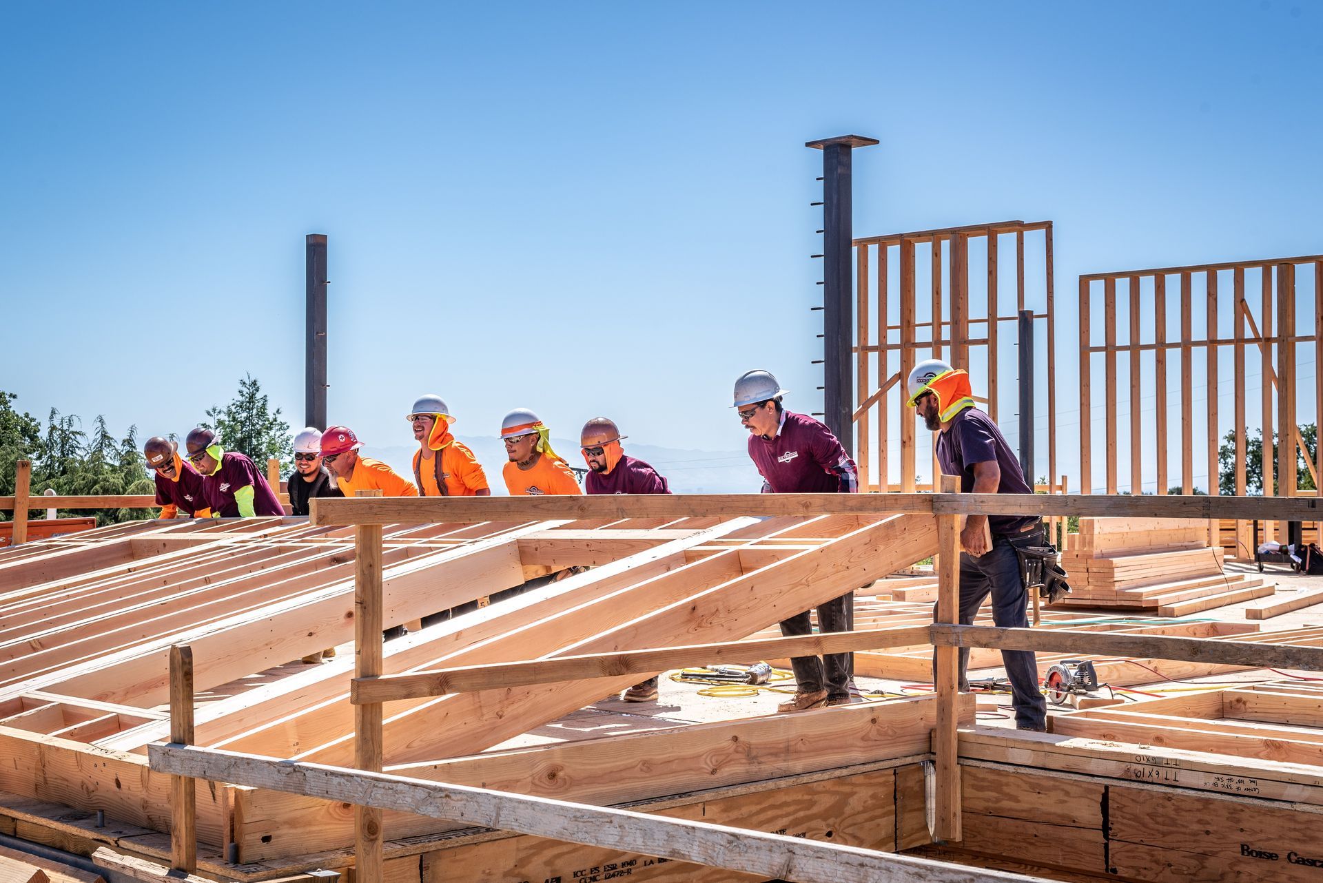 Construction workers framing a building foundation under a clear blue sky