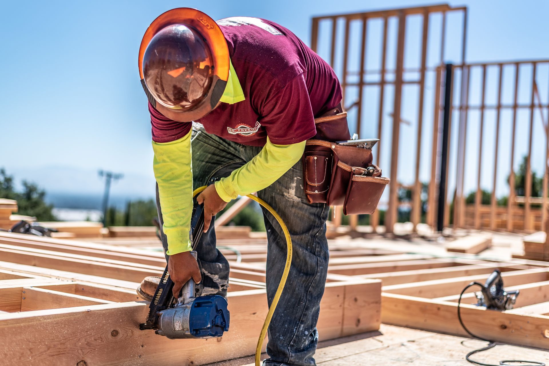 Worker using a circular saw on a wooden frame at a construction site