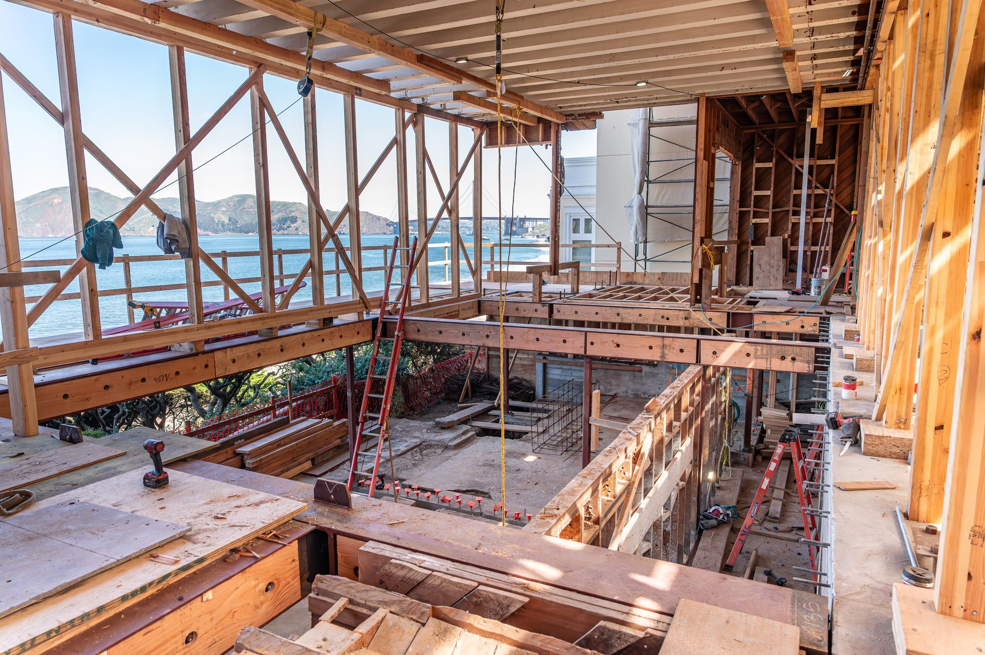 Partially built interior with wood framing, scaffolding, and open ocean views