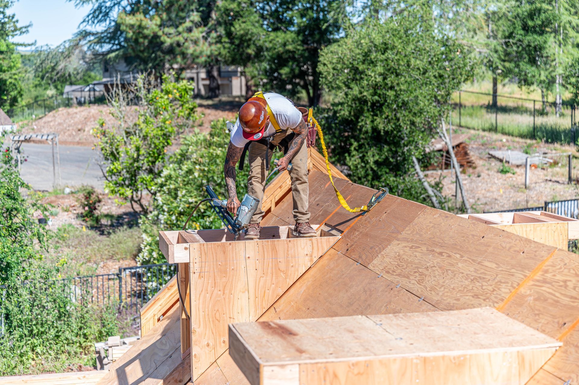 Worker installing roofing on a wooden roof frame outdoors