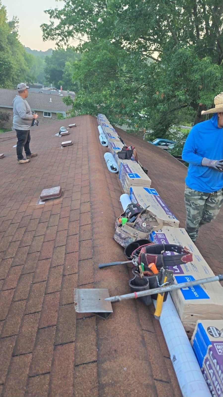 Long brick walkway lined with tools and supplies, with two people standing nearby outdoors. Long brick walkway lined with tools and supplies, with two people standing nearby outdoors.