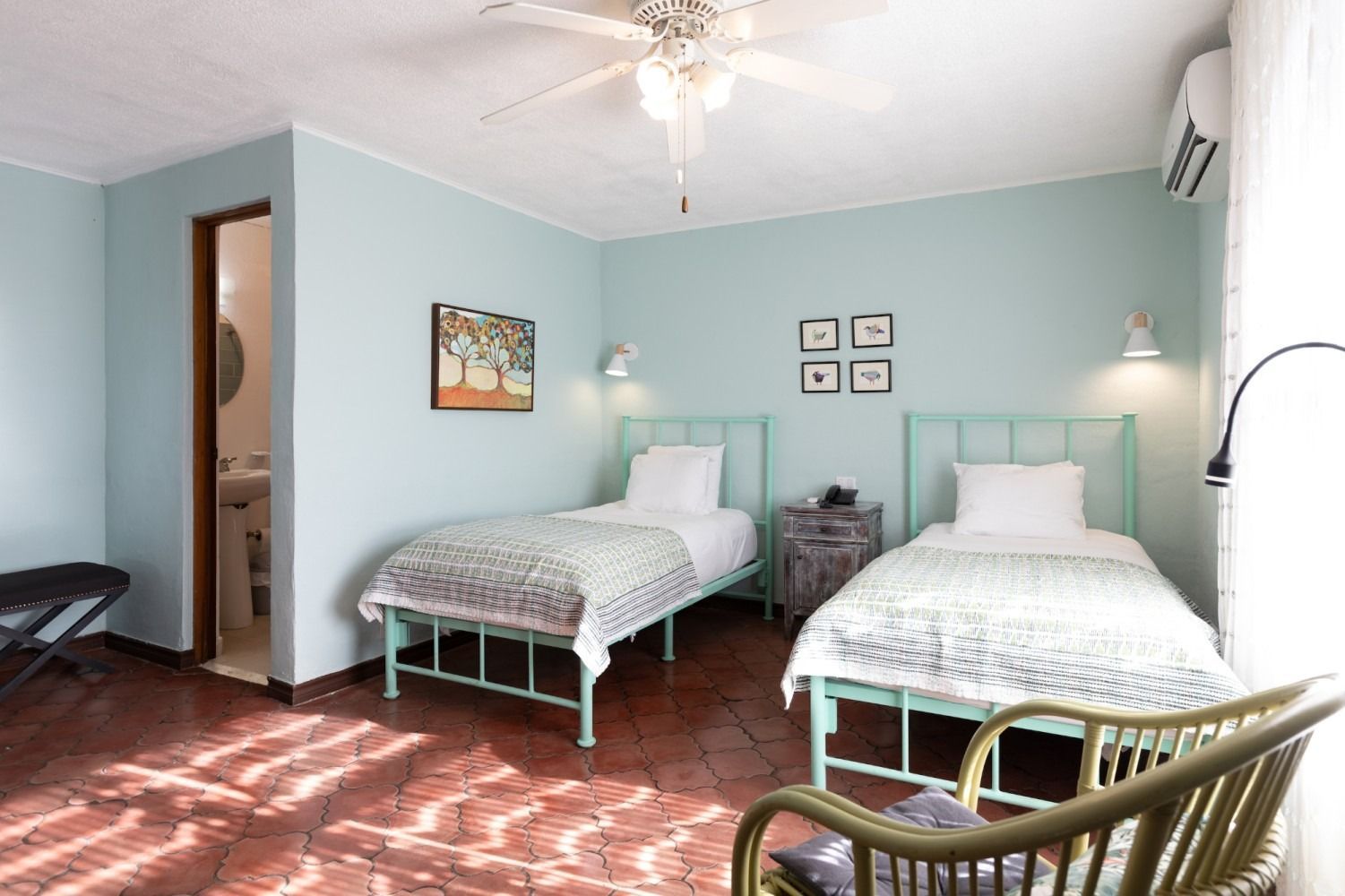 A bedroom with a large bed , chair , sliding glass doors and a ceiling fan.