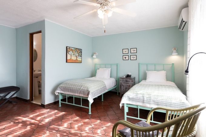 A bedroom with two beds , a chair and a ceiling fan.
