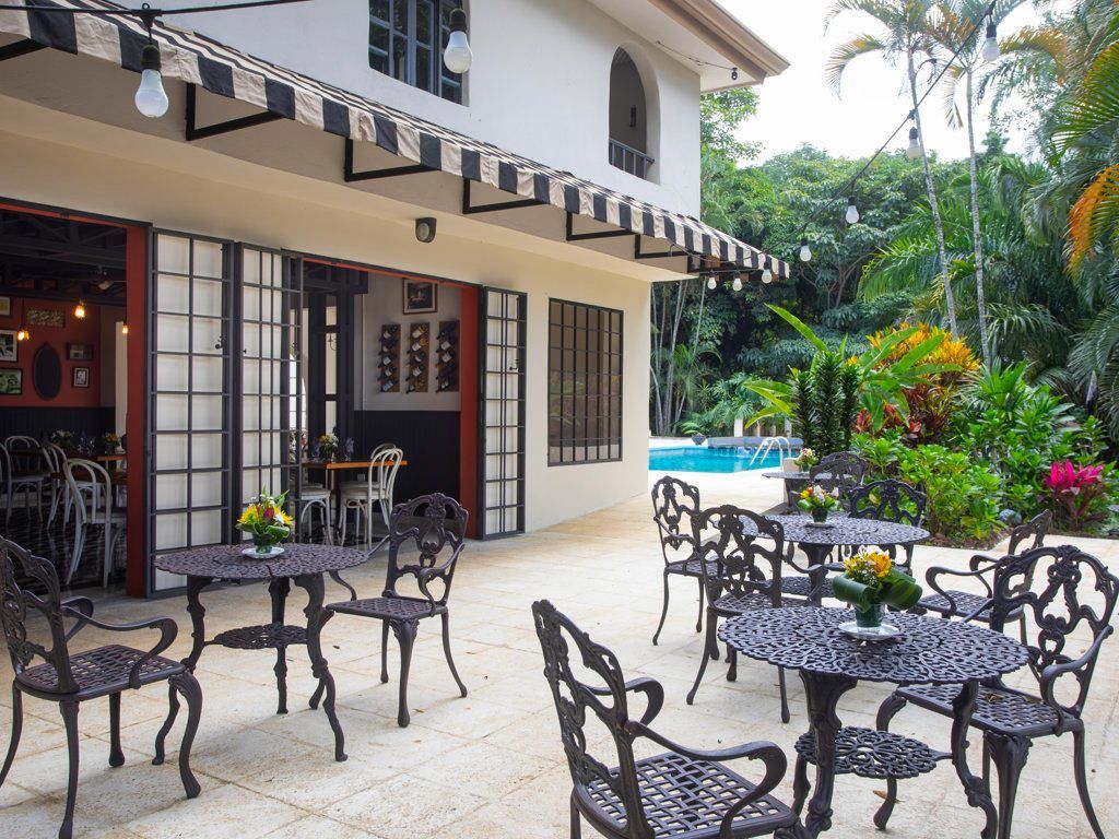 A patio with tables and chairs in front of a house.