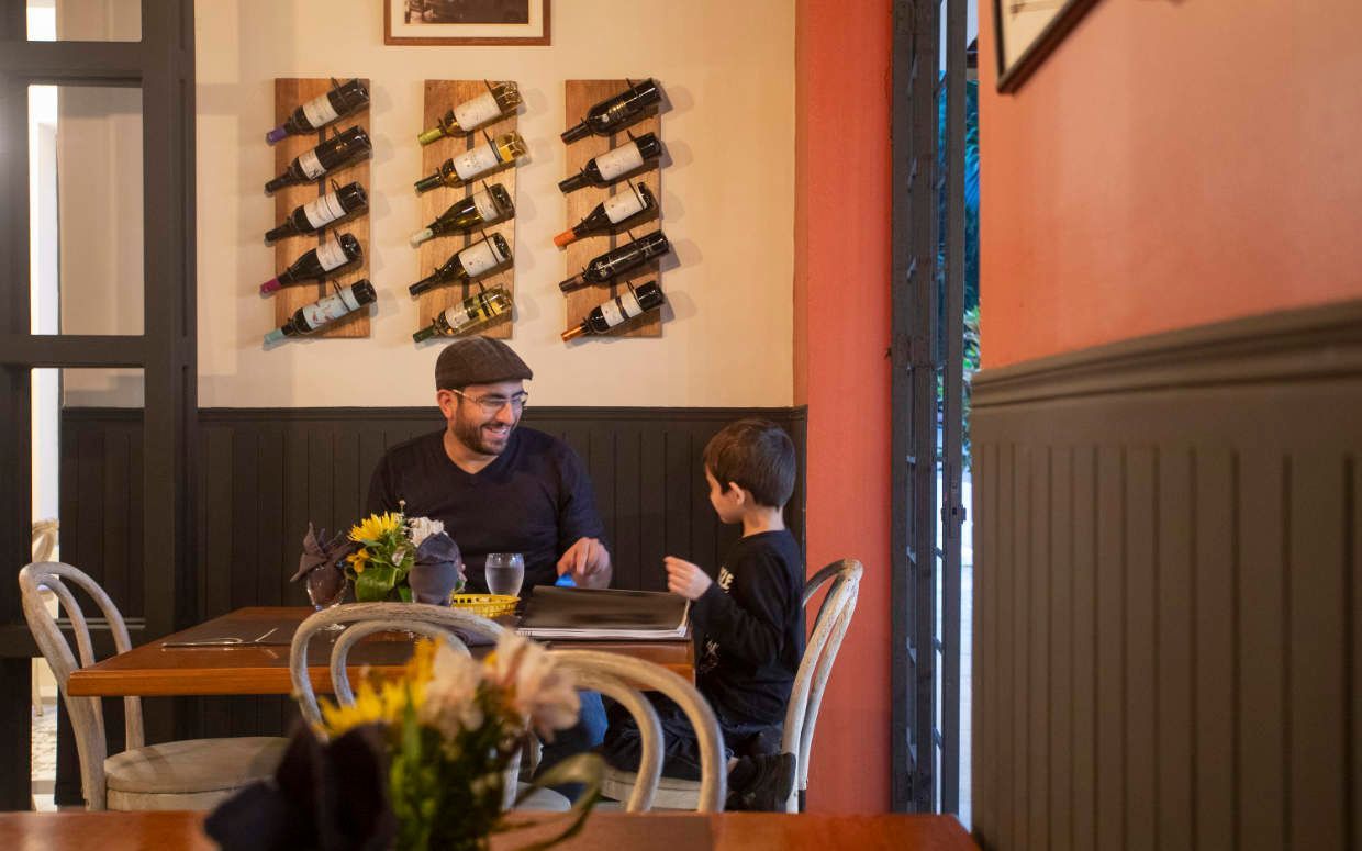 A man and a child are sitting at a table in a restaurant.
