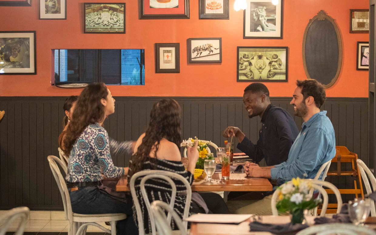 A group of people are sitting at tables in a restaurant.