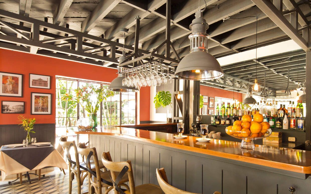 A restaurant with a long bar and tables and chairs