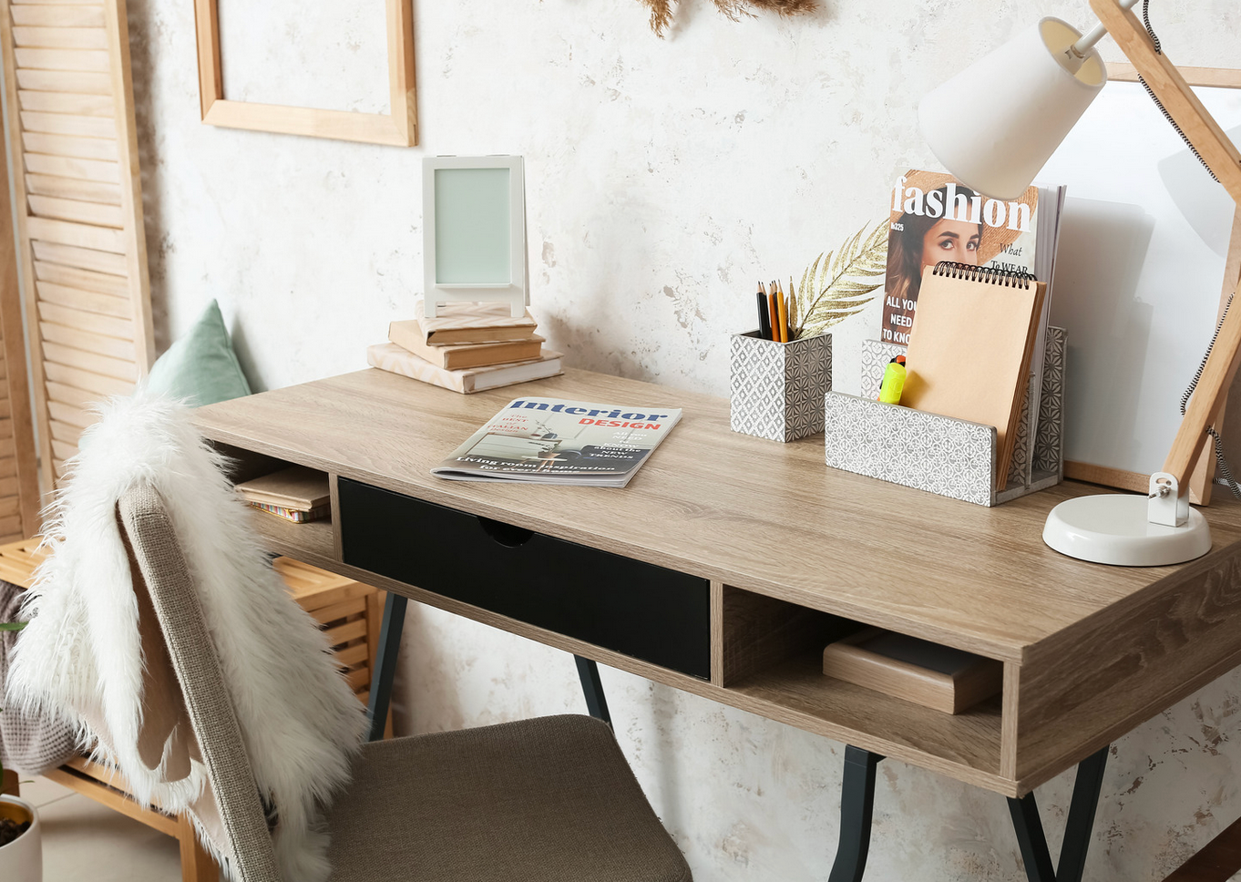 A wooden desk with a chair and a lamp on it.