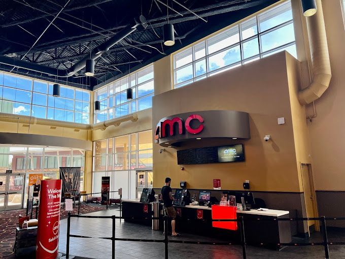 A large room with a lot of windows and a sign that says amc