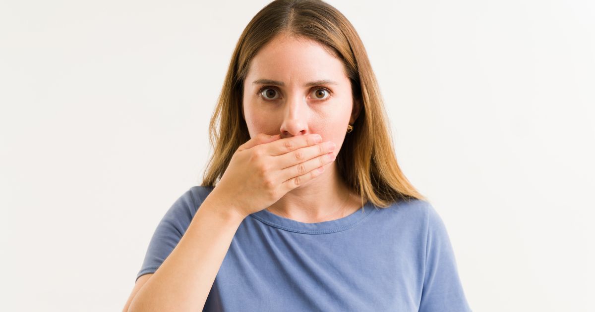Person Covering Their Mouth With One Hand — Trinity Beach Dental In Trinity Beach, QLD