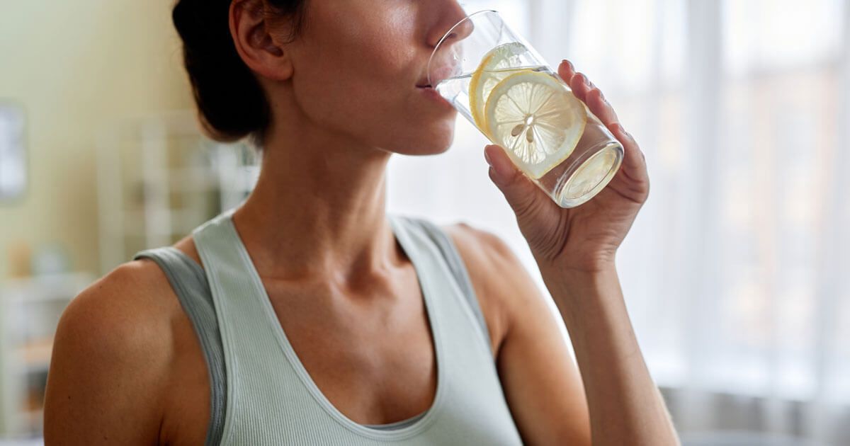 Woman in a Light Tank Top Drinking Water From a Glass — Trinity Beach Dental In Trinity Beach, QLD