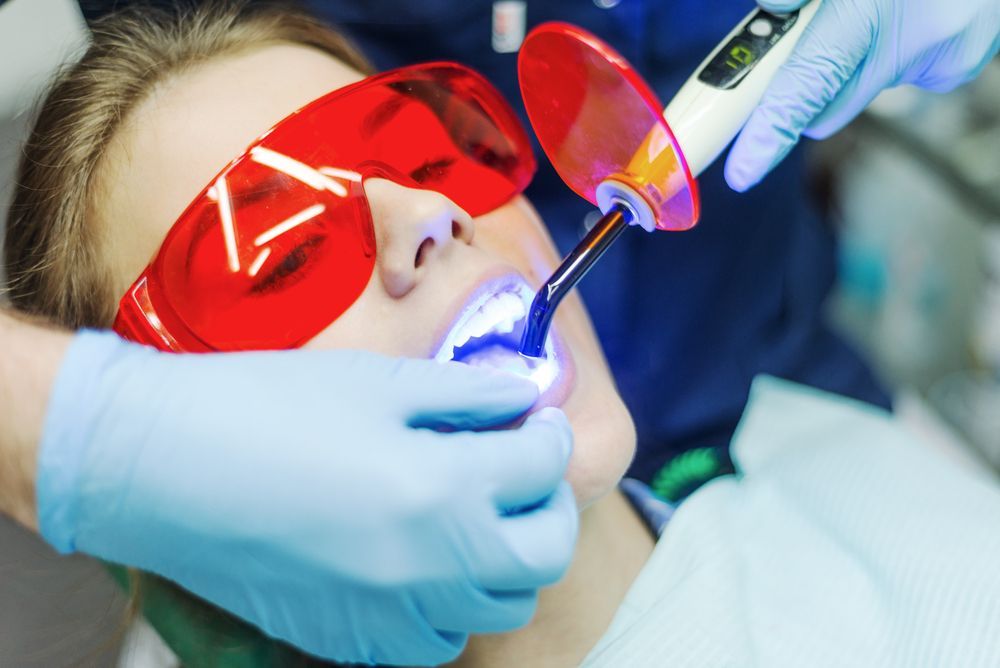 Dentist Using Blue Light to Treat Patient's Teeth — Trinity Beach Dental In Trinity Beach, QLD