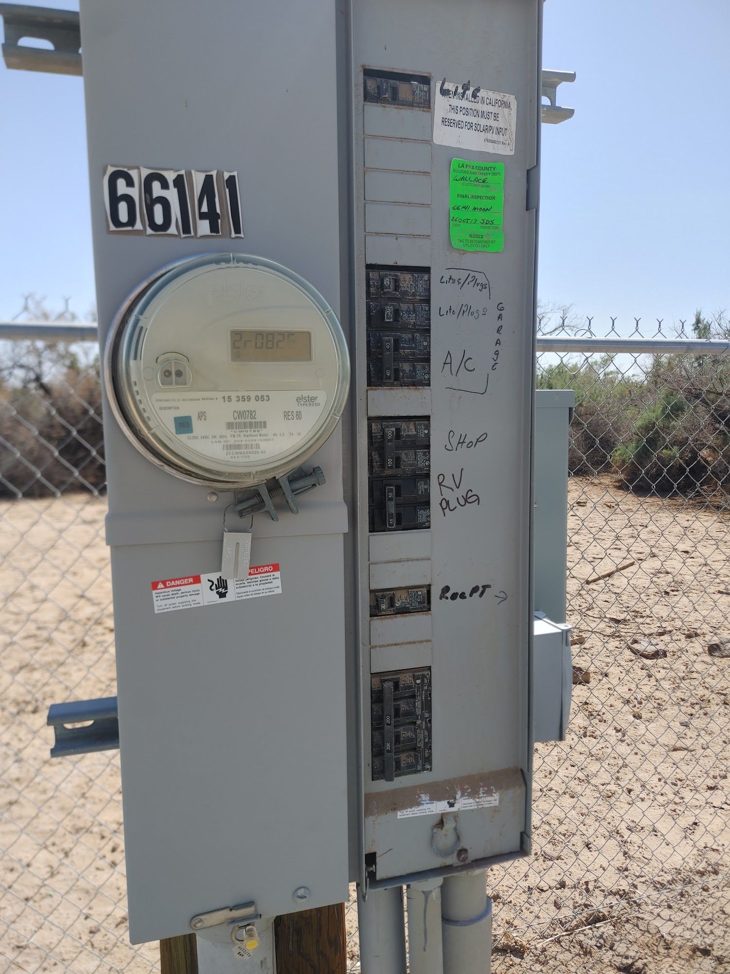 Outdoor electrical panel with meter, breakers, and handwritten labels. Numbered 66141.
