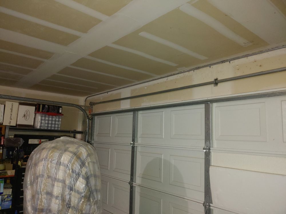Garage interior with white garage door, tracks, and a section of ceiling.