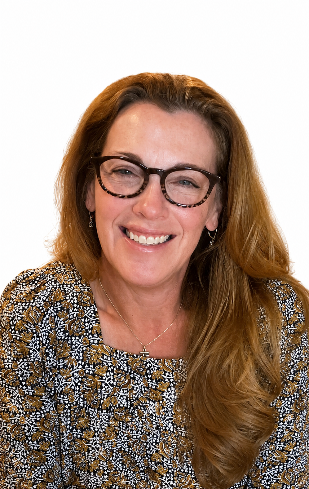 Tina Wright with reddish-brown hair smiles, wearing a glasses.